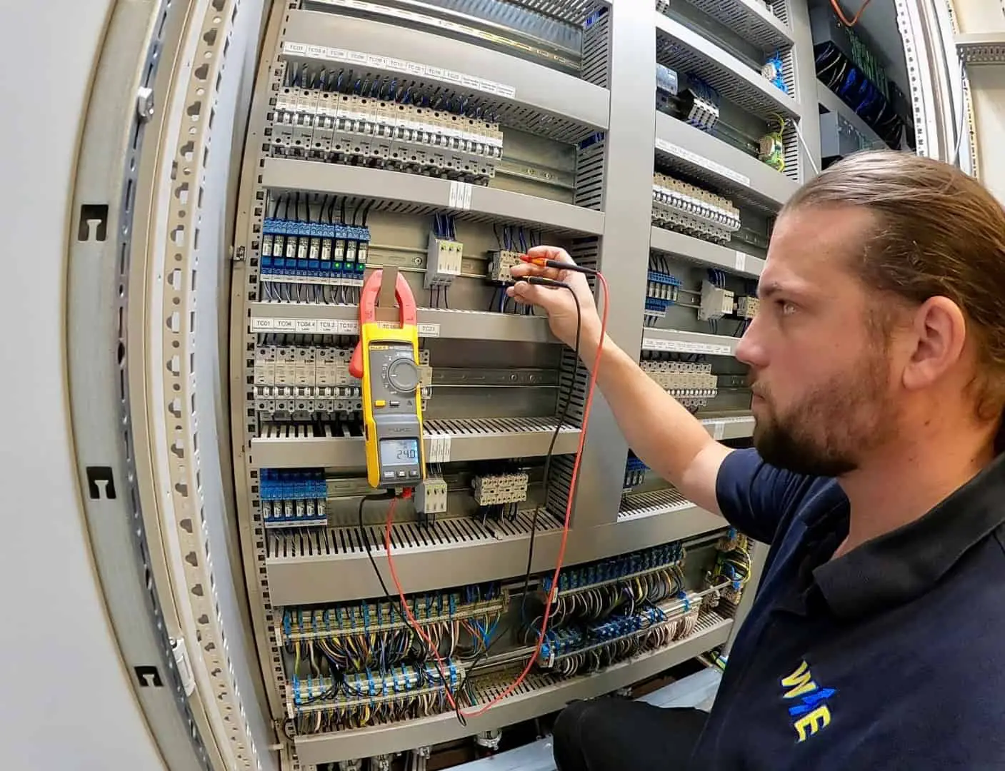 Elektrotechniker misst Spannungen im Schaltschrank mit Multimeter bei Wartung und Fehlersuche